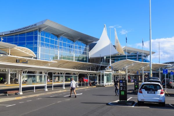 an airport building with glass windows and a parking lot